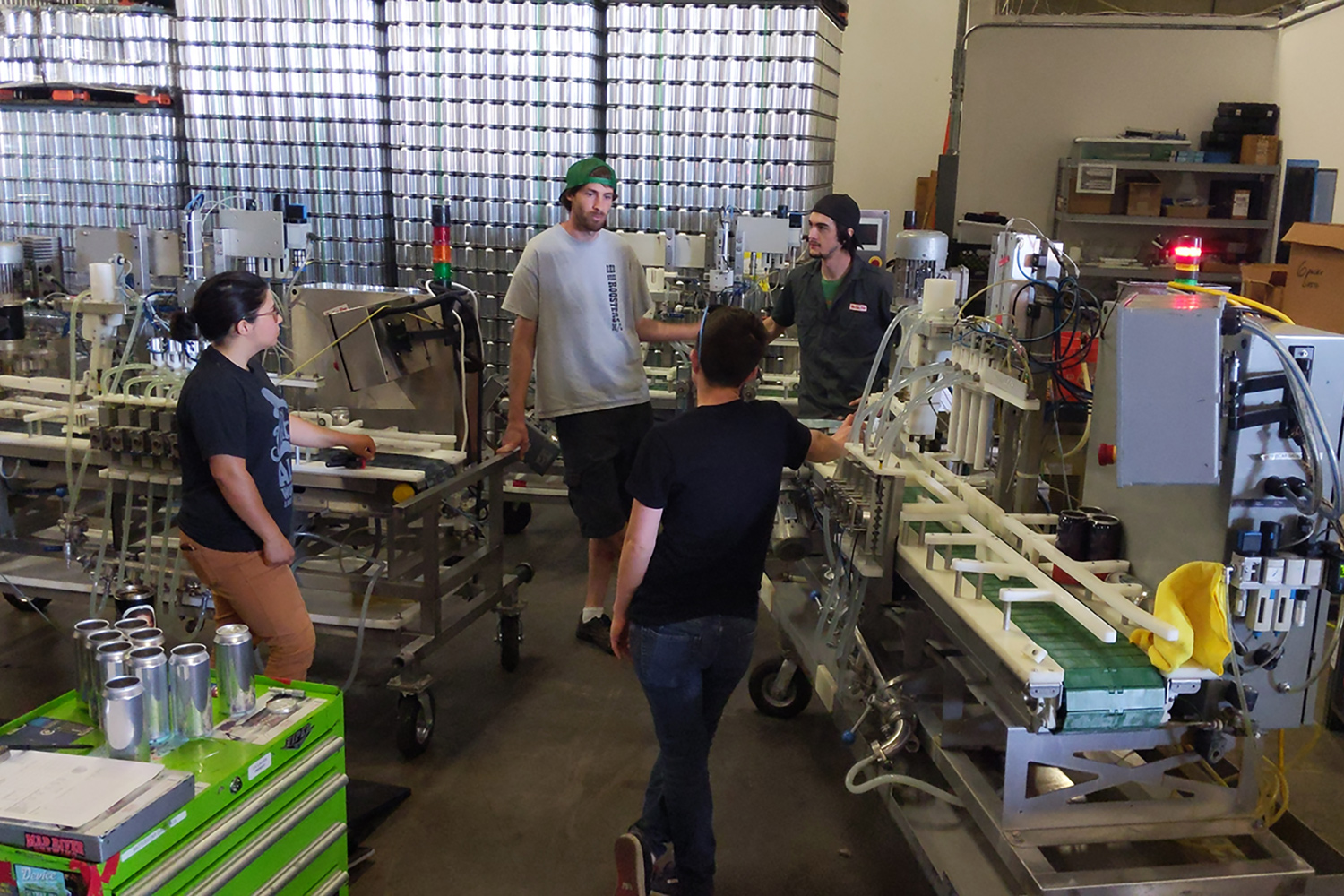 Sarah, Wade, Lindsey, and Camreon having a chat in the warehouse next to a couple of the canning lines